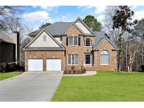 Charming two-story brick home featuring a well-manicured lawn and a two-car garage at 136 Golden Aster Trce, Acworth, GA 30101
