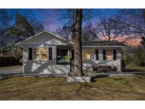 Charming home featuring a brick facade, black shutters, and a cozy front porch sitting area at 850 Third St, Stone Mountain, GA 30083