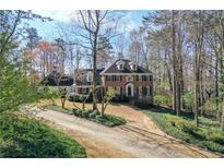 Charming brick two-story home with a manicured front yard and a long driveway at 3320 Donegal Way, Snellville, GA 30039