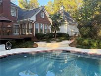 Inviting backyard pool area with landscaped surroundings and stylish deck features for outdoor relaxation at 3320 Donegal Way, Snellville, GA 30039