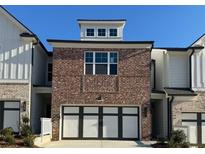 Charming brick townhome with a two-car garage and white trim details at 258 Depot Landing Rd # 53, Auburn, GA 30011