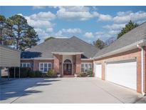 A stately brick home with a large driveway and two-car garage, exudes classic charm at 520 Camp Perrin Rd, Lawrenceville, GA 30043