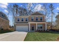 Charming two-story brick home with a manicured lawn and covered front porch at 249 Chiswick Loop, Stockbridge, GA 30281