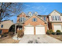 Charming brick townhome featuring a two-car garage and well-maintained landscaping at 5751 Evadale Trace, Mableton, GA 30126