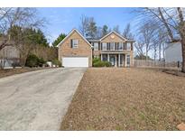 Traditional two-story brick home featuring an attached two-car garage and well-maintained front lawn at 692 Sedgwick Dr, Jonesboro, GA 30238