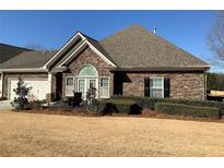 Charming stone-clad house with manicured lawn and inviting outdoor patio area at 3311 Lindenridge Dr, Buford, GA 30519