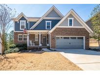 Charming two-story brick home with a well-manicured lawn, covered porch, and a two-car garage at 139 Stargaze Rdg, Canton, GA 30114