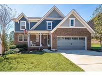 Charming two-story home with a brick and blue exterior, inviting front porch, and manicured lawn at 139 Stargaze Rdg, Canton, GA 30114