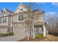 Charming two-story townhome featuring a stone facade and an attached two-car garage at 3238 Spicy Cedar Ln, Lithonia, GA 30038