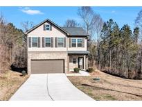 Charming two-story home featuring a brick and vinyl facade, attached garage, and well-manicured lawn at 201 Chert Way, Atlanta, GA 30349