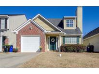 Charming two-story home featuring a brick accent, a well-kept yard, and an attached garage at 4119 Ravenwood Ct, Union City, GA 30291