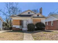 Exterior shot of boarded house with small yard and brick foundation and chimney at 1046 Katherwood Sw Dr, Atlanta, GA 30310