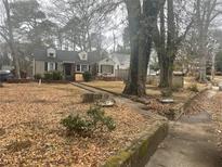 Charming single-Gathering home featuring a manicured lawn and mature trees on an overcast day at 1779 South Gordon Sw St, Atlanta, GA 30310