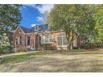 Charming brick home with a well-manicured lawn, mature trees, and classic architectural details at 2876 Alpine Ne Rd, Atlanta, GA 30305
