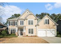 Inviting two-story home featuring a manicured lawn, neutral siding, and a convenient two-car garage at 1641 Heathermoor Way, Dacula, GA 30019