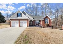 Charming brick home featuring a two-car garage and a well-maintained front lawn at 2720 Araglin Dr, Dacula, GA 30019