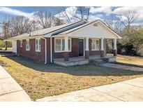 Charming brick home featuring a covered front porch with classic columns at 1729 Spring Ne St, Conyers, GA 30012