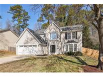 Charming two-story home with a well-maintained lawn, attached garage, and mature trees at 5320 Taylor Rd, Johns Creek, GA 30022