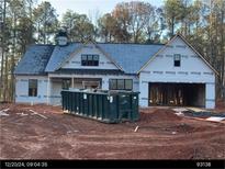 New construction home featuring a spacious layout and attached two-car garage, set against a backdrop of mature trees at 10 Harmony Ridge Dr, Temple, GA 30179