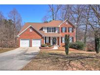 Charming two-story brick home with a well-manicured lawn, two-car garage, and inviting front entrance at 1021 Crooked Creek Se Ct, Mableton, GA 30126