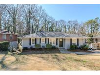 Charming single-story home with a gray exterior, trimmed bushes, and a well-manicured lawn at 1662 Flintwood Se Dr, Atlanta, GA 30316
