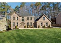Brick two-story home with a well manicured lawn and mature trees at 5956 Henley Dr, Powder Springs, GA 30127