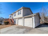 Exterior of home showing two car garage, side entry, and wood steps leading to a second story entrance at 6138 Raleigh Oaks Ct, Lithonia, GA 30058