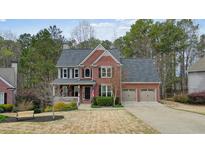 Charming two-story brick home with a covered front porch and attached two-car garage at 616 Redwood Ln, Canton, GA 30114