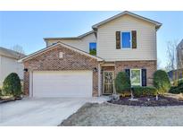 Charming two-story home featuring a brick and siding exterior with an attached two-car garage at 6574 Barker Station Walk, Sugar Hill, GA 30518