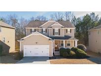 Charming two-story home featuring a welcoming front porch, attached garage, and well-maintained landscaping at 977 Forest Knoll Ct, Lithia Springs, GA 30122