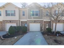 Charming townhome featuring a brick facade, an attached garage, and a well-manicured front yard at 3293 Pennington Dr, Stonecrest, GA 30038