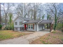 Charming home featuring a carport, red front door, grey siding, and painted brick foundation at 2304 Wesley Chapel Rd, Decatur, GA 30035