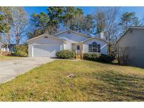 Charming single-story home with a manicured lawn, attached garage, and inviting front entrance at 6381 Phillips Creek Dr, Lithonia, GA 30058