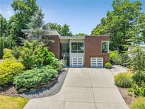 Contemporary brick home with a two-car garage and professionally landscaped front yard at 1002 Citadel Ne Dr, Atlanta, GA 30324