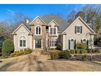 Charming two-story home with stone accents, lush landscaping, and a well-manicured lawn creates instant curb appeal at 8210 Sentinae Chase Dr, Roswell, GA 30076