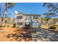 Charming two-story home featuring a front yard with a driveway and red window shutters at 7592 Didwell Ct, Jonesboro, GA 30236