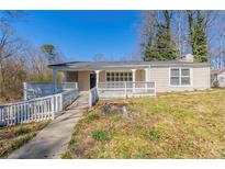 Charming single-story home featuring a covered porch, accessible ramp, and a well-maintained front yard at 940 Blair Bridge Rd, Austell, GA 30168