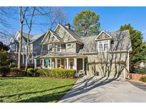 Charming two-story home with manicured front yard and inviting covered porch at 1898 Woodland Hills Nw Ave, Atlanta, GA 30318