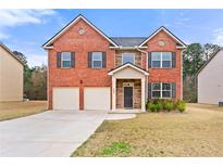 Charming two-story brick home with a two-car garage and well-manicured lawn at 1695 Beckworth Ln, Hampton, GA 30228