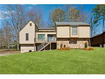 Charming home showcasing a well-manicured lawn, inviting stairway, and a mix of stone and traditional siding at 2635 Alberta Ln, Marietta, GA 30062