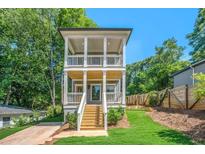 Charming two-story home with double porches, a modern staircase, and a well-manicured lawn at 57 Moury Se Ave, Atlanta, GA 30315
