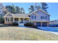 Charming two-story home featuring a brick and gray siding exterior, well-manicured lawn, and a two-car garage at 3736 Rainbow Cir, Snellville, GA 30039