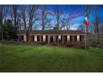 Charming brick home with well-manicured lawn and a flag pole in the front yard against a colorful sky at 3250 N Embry Cir, Atlanta, GA 30341