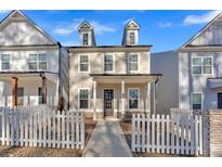 Charming two-story home featuring a welcoming front porch and a classic white picket fence at 629 Everett Ln, Woodstock, GA 30188