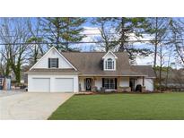 Charming exterior of a well-maintained home with a two-car garage and inviting front porch at 159 Sequoyah Cir, Canton, GA 30115