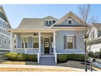 Charming light blue home featuring a welcoming front porch, well-manicured landscaping, and architectural details at 208 Haralson Ne Ln, Atlanta, GA 30307