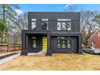 Modern two-story home with a flat roof, black exterior and bright yellow front door at 2402 Lynn Iris Dr, Decatur, GA 30032