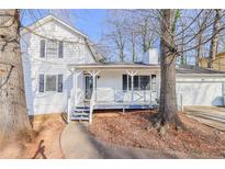 Charming two-story home featuring a covered front porch and a well-maintained yard with mature trees and a two-car garage at 3661 Silver Leaf Sw Ln, Marietta, GA 30008