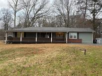 Charming single-story home featuring a covered porch and mature trees in a serene setting at 4749 Cox Se St, Acworth, GA 30101