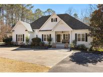 Charming single-story home with white siding, dark shutters, and a welcoming front porch with rocking chairs at 105 Leisure Trl, Peachtree City, GA 30269